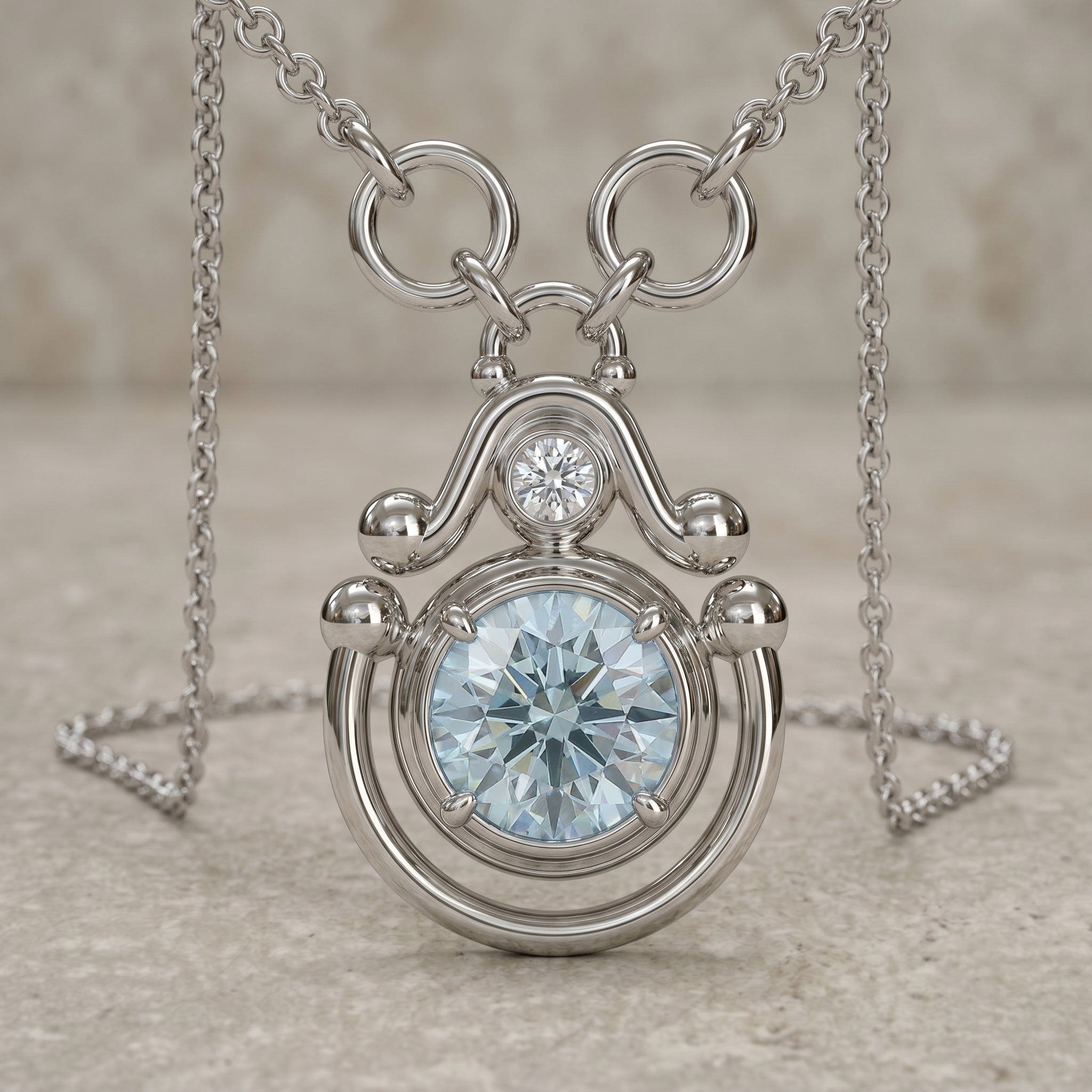 Silver necklace with a round pendant featuring a blue gemstone on a neutral background