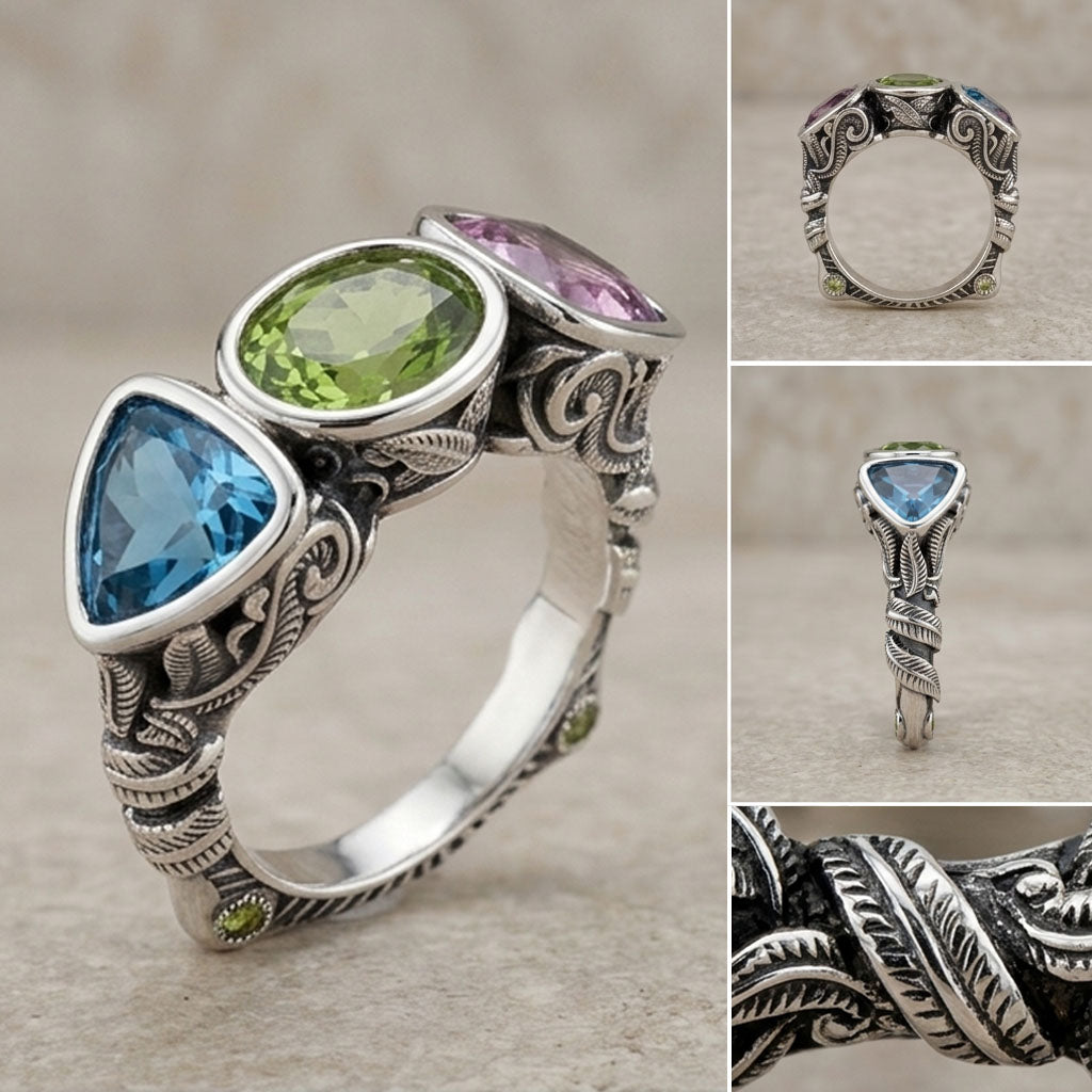 Silver ring with green, pink, and blue gemstones on a textured surface