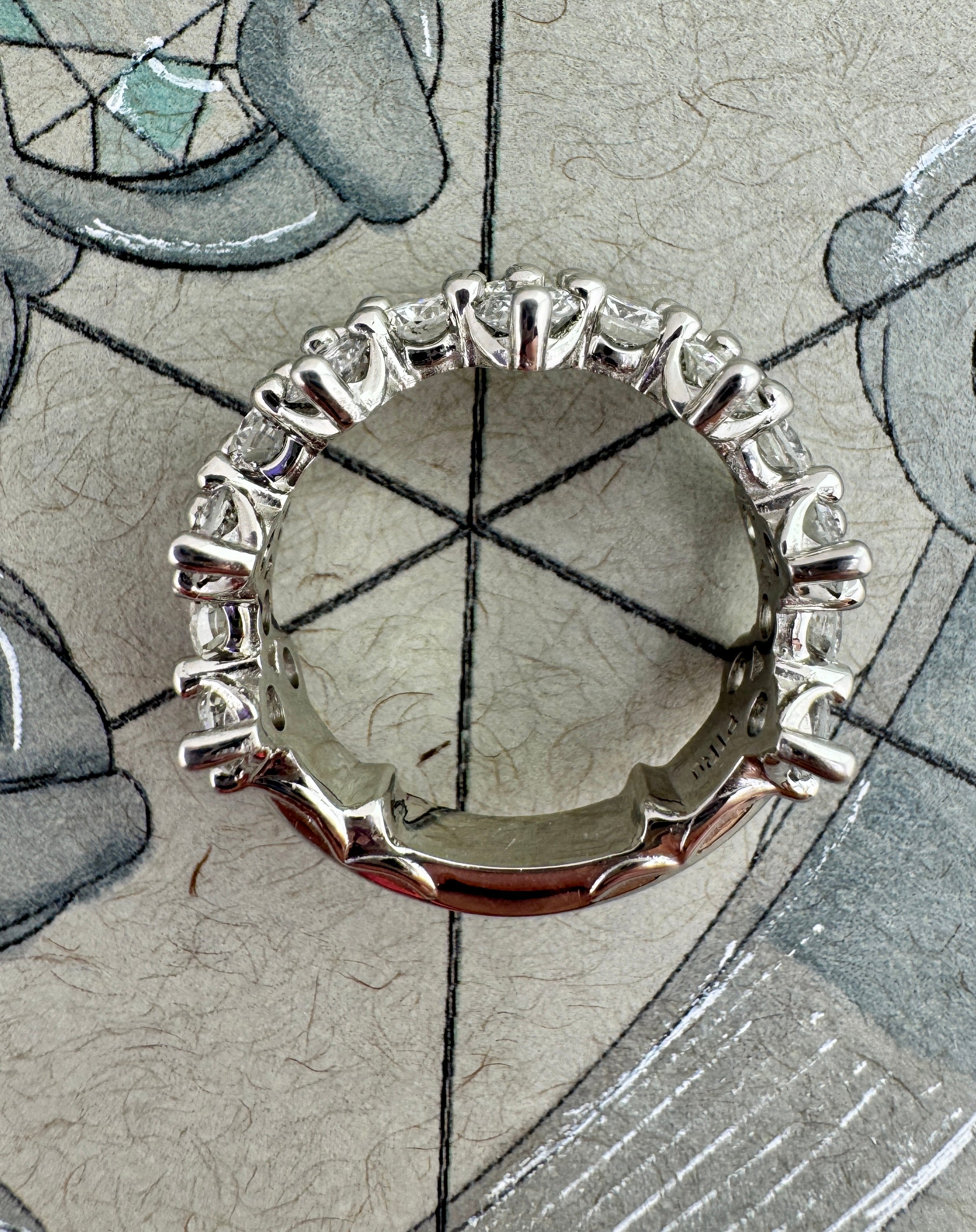 Silver ring with diamonds on a textured surface