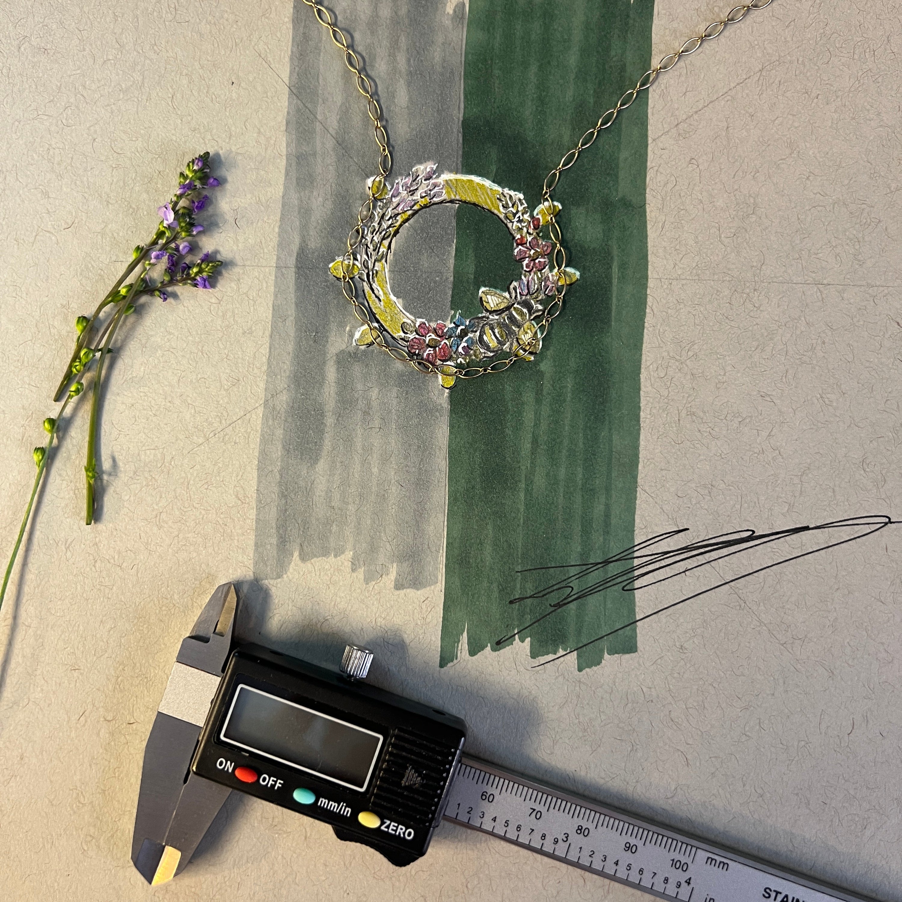Decorative wreath with colorful stones, a ruler, and digital caliper on a textured surface.