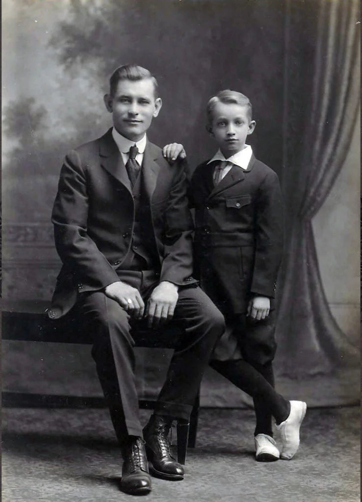 Black and white photo of man and small boy in old fashioned clothing