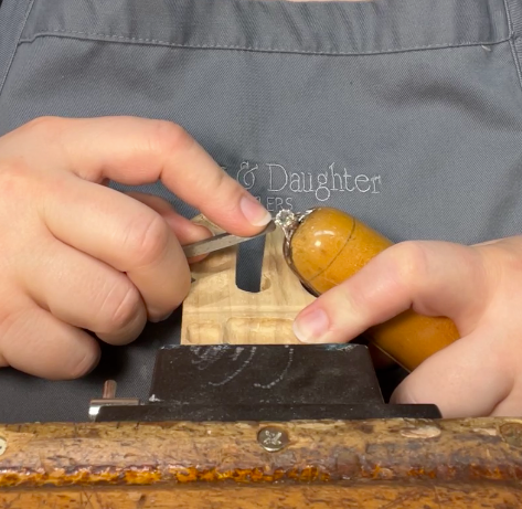 Sophie Stradley setting a stone in a ring with 'Stradley & Daughter' branding in the background.