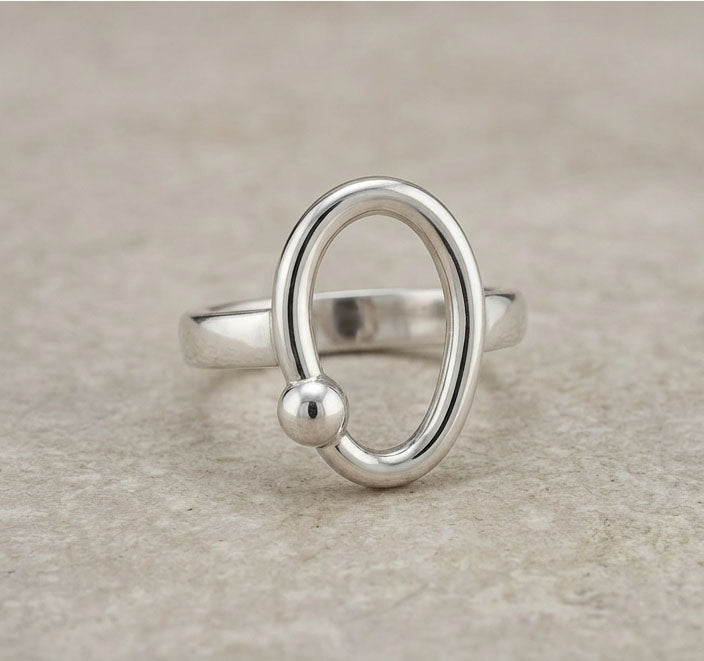 Silver ring with a unique design on a beige background