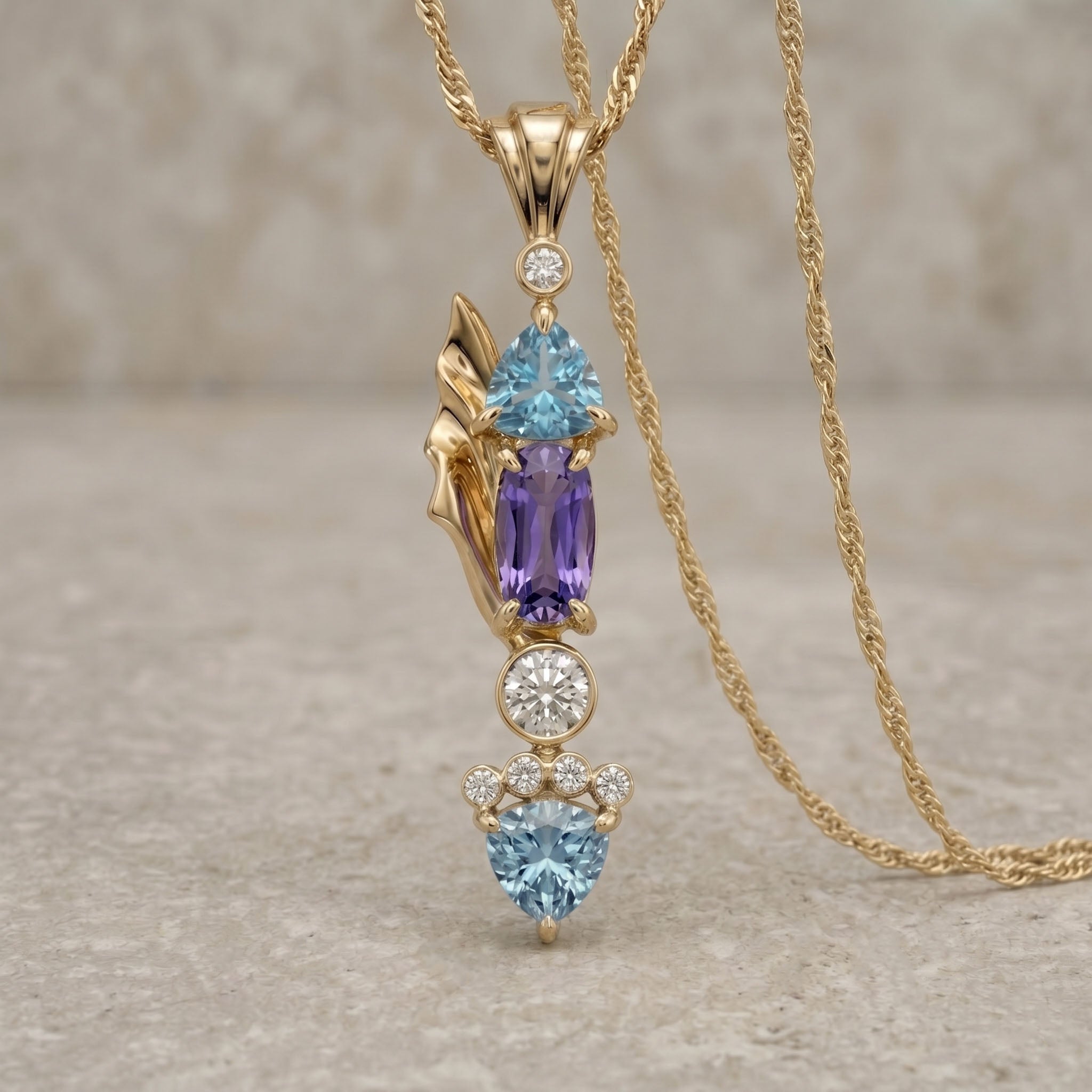 Gold necklace with gemstone pendant on a textured surface